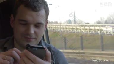 年轻的微笑的人旅行的火车和使用智能手机，他发送信息和看着窗外